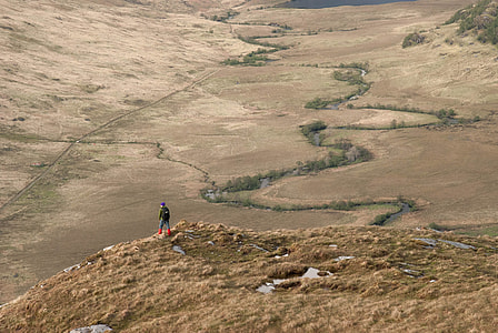 photography of man standing on the edge on the mountain thumbnail