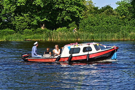 three people riding on white boat while traveling on body of water thumbnail