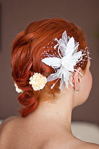 woman wearing white floral hair accessory and silver-colored hoop earring thumbnail
