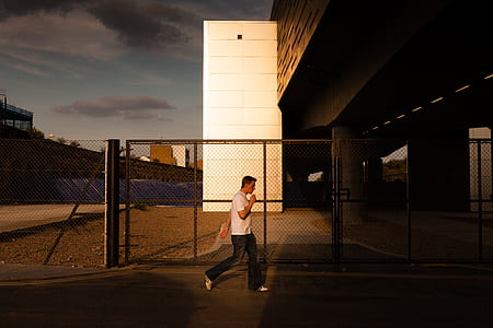 man standing near gray fence thumbnail