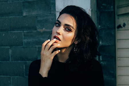 woman in black top holding her lower lip thumbnail