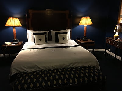 person taking photo of bedroom with table lamp turned on thumbnail