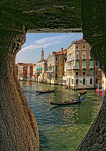 boats on green body of water near concrete buildings during daytime thumbnail