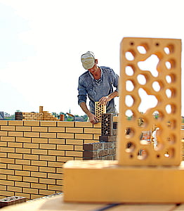 man building wall during daytime thumbnail