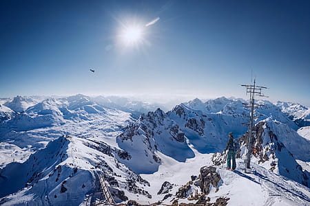 Person on Top of Snow Covered Mountain Under Clear Blue Sky thumbnail