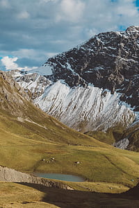 landscape photography of hill and snow covered mountain thumbnail