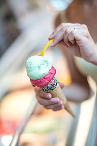 Person Holding Ice Cream and Yellow Spoon thumbnail