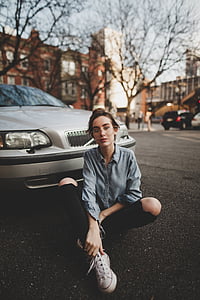woman sitting on ground beside car thumbnail
