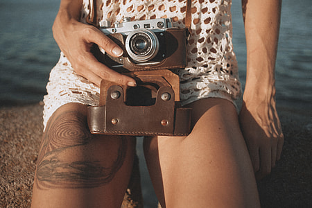 person with tattoo holding mirrorless camera thumbnail