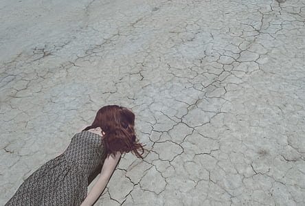 woman wearing gray sleeveless dress lying on ground during daytime thumbnail