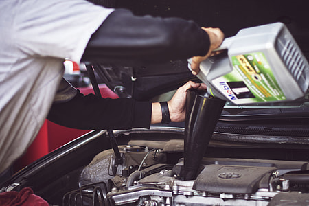 person filling gasoline on engine bay thumbnail