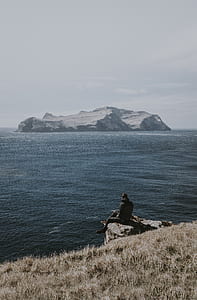 man sitting on mountain cliff thumbnail