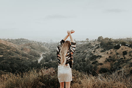 woman standing on high ground in front of mountains thumbnail