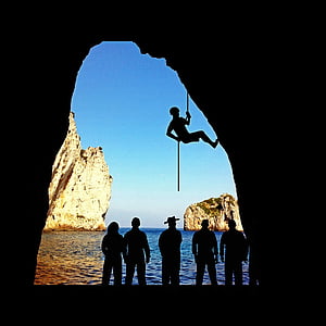 silhouette of person climbing in cave thumbnail