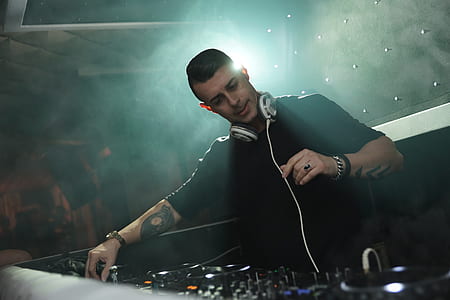 male DJ in front of DJ mixer thumbnail