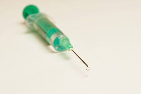 green syringe on white surface thumbnail