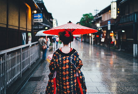 Geisha walking on street during rainy day thumbnail