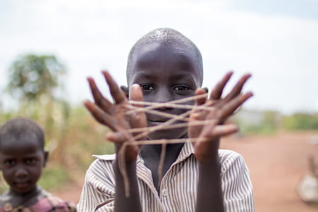 boy holding thread tied on hands thumbnail