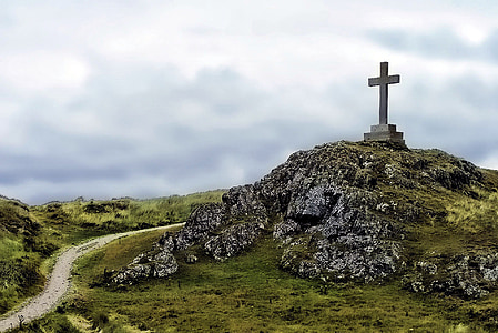 cross on cliff under cumulus clouds during golden hour thumbnail