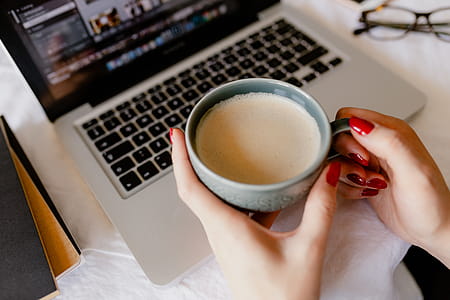 A woman works at a desk with a laptop and a cup of coffee thumbnail