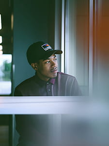 man wearing cap near window thumbnail