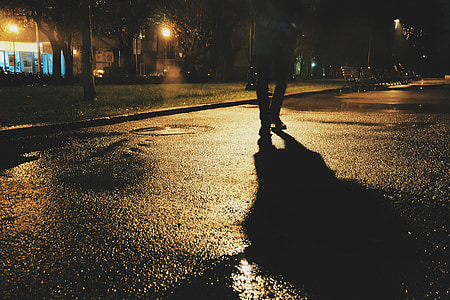 man standing on concrete road during nighttime thumbnail