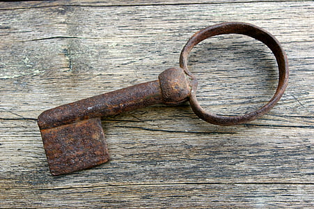 rusted brown skeleton key on brown wooden board thumbnail