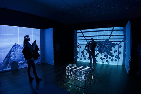 two people standing in dark room with projection thumbnail