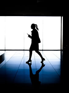 silhouette of a woman walking in dark room thumbnail