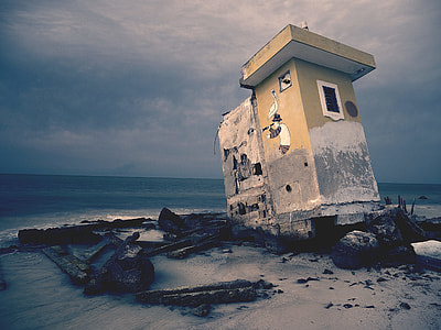 abandoned gray concrete house on seashore near sea thumbnail