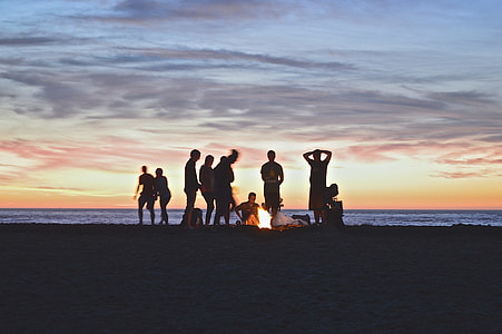 people creating bonfire near ocean thumbnail