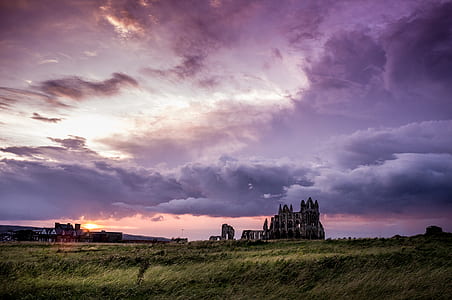 Green Field and White and Black Concrete Structure during Sunset thumbnail