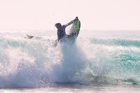 man riding surf board at day time thumbnail