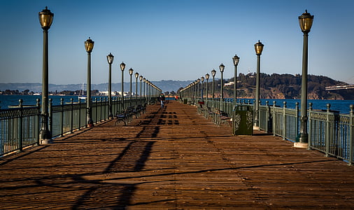 brown wooden pier with black lamp post on each side thumbnail