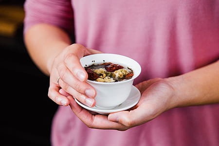 tilt-shift lens photo of person holding white ceramic bowl and saucer thumbnail