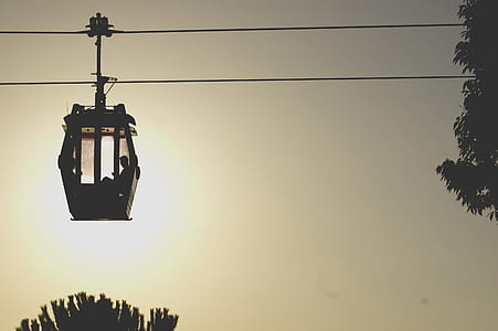 person sitting in cable car silhouette during golden hour thumbnail