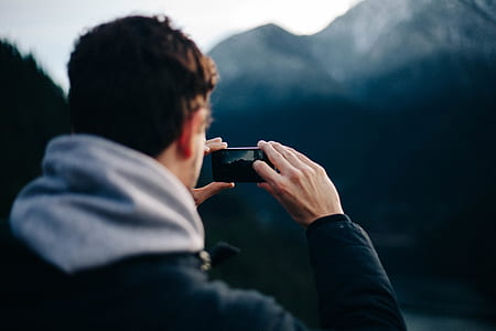 man taking picture of a mountain thumbnail