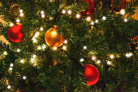 turned-on string lights on Christmas tree beside baubles thumbnail