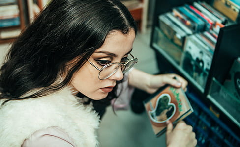 woman wearing fur jacket holding photo album inside room thumbnail