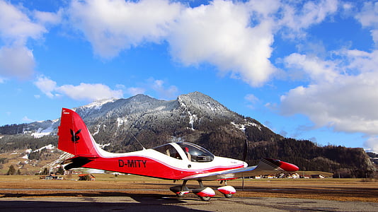 red and white plane on field under cloudy sky thumbnail