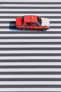 red and white sedan passing on white lanes thumbnail