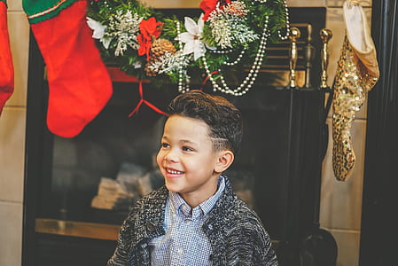 boy smiling below Christmas decors thumbnail