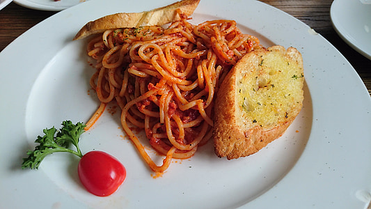 toasted bread beside spaghetti and sliced tomato on plate thumbnail