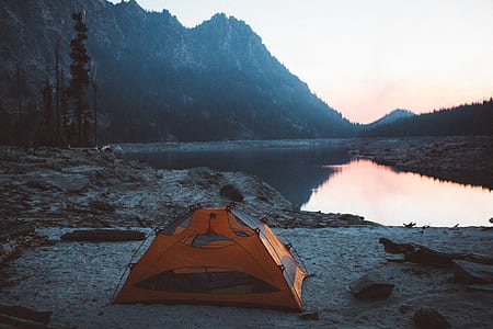 orange tent near body of water during morning thumbnail