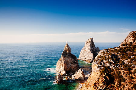 cliff and body of water landscape photography thumbnail
