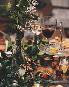 selective focus photography of baby's breath flowers in clear vase beside pinecones and clear glass 2-layer cupcake stand thumbnail