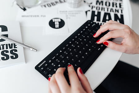 Female hands typing on the remote wireless computer keyboard thumbnail