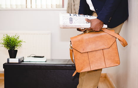 person holding brown leather crossbody bag thumbnail