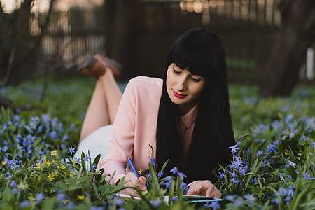 woman writing on book during daytime thumbnail