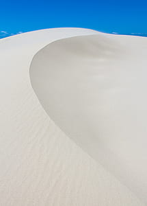 brown sand under clear blue sky at daytime thumbnail